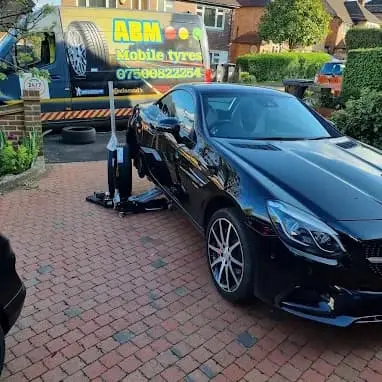 ABM Mobile Tyres performing mobile tyre replacement on a black Mercedes-Benz convertible on a residential driveway